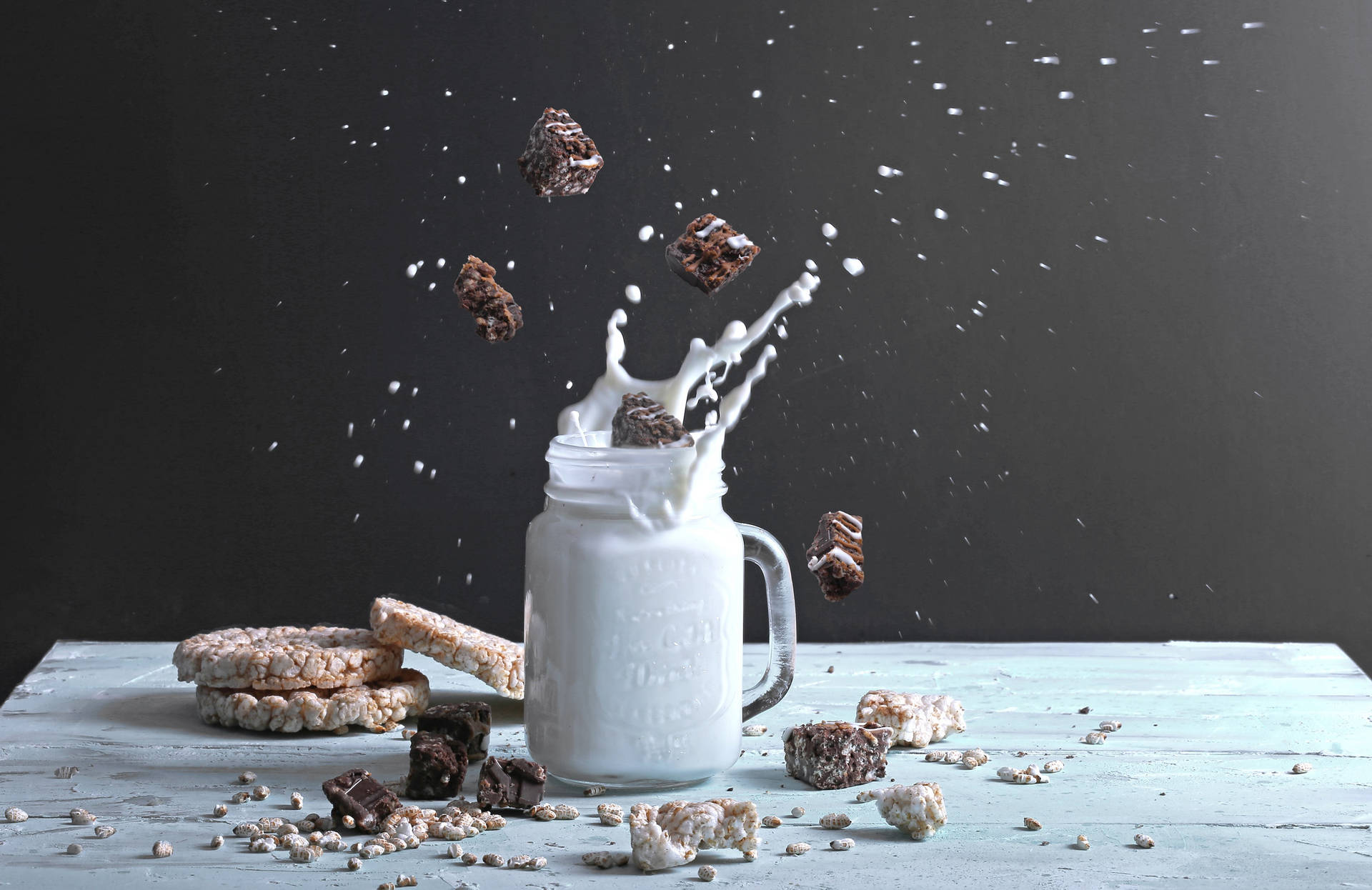 Caption: Delicious Fudge Brownies Splashing Into Fresh Milk Background