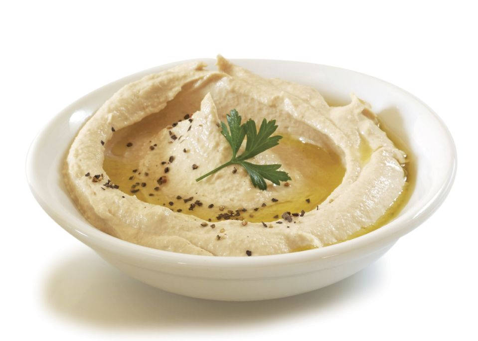 Caption: Delicious Hummus Served In A White Bowl Background