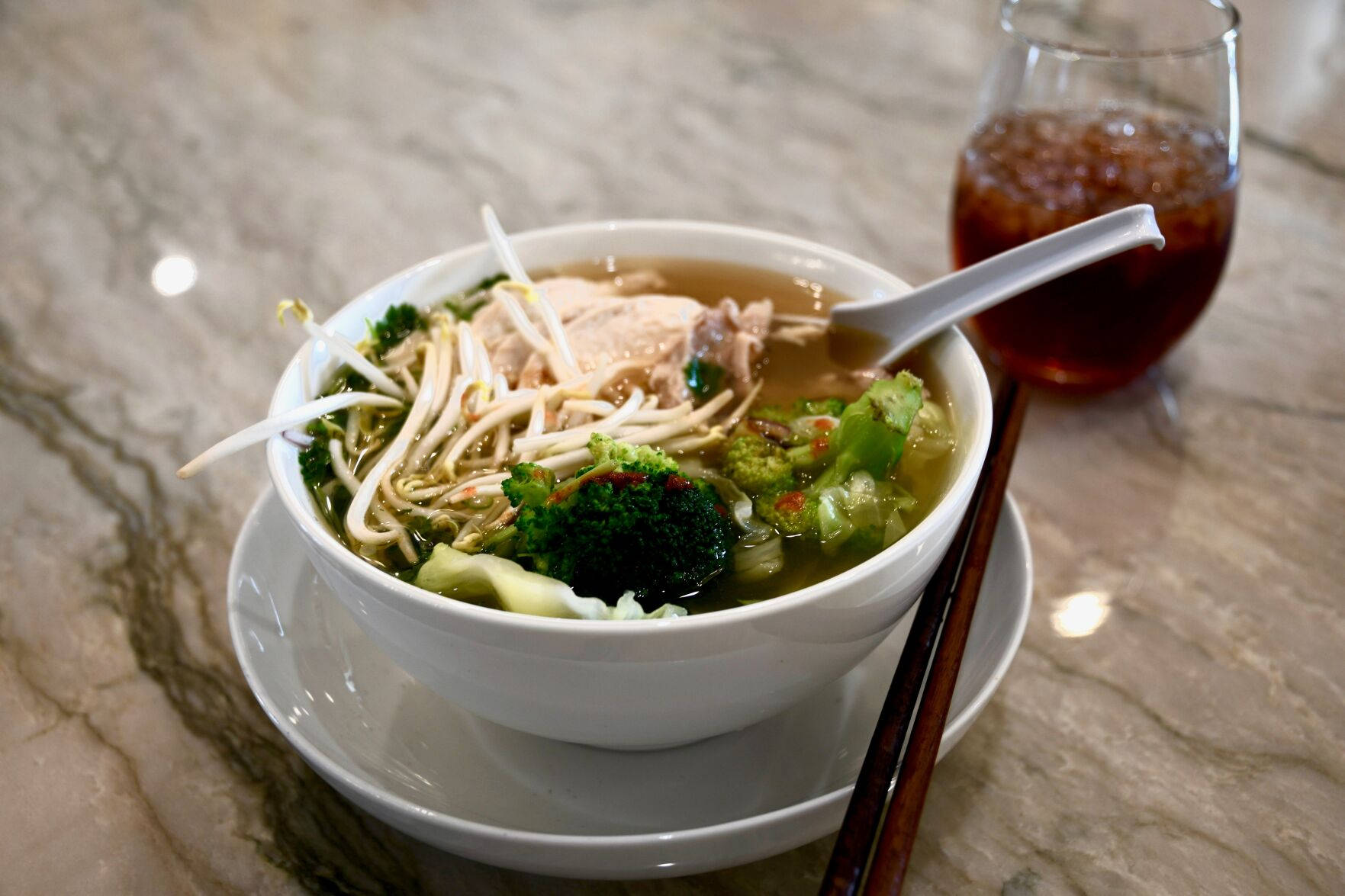 Caption: Delicious Pho Noodle Soup With Fresh Vegetables Background