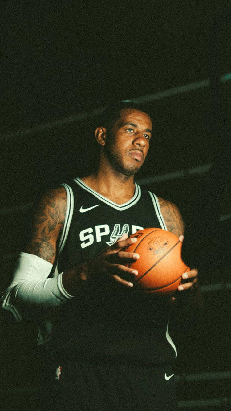 Caption: Dominant Basketball Player, Lamarcus Aldridge, Illuminated In Shadows Background