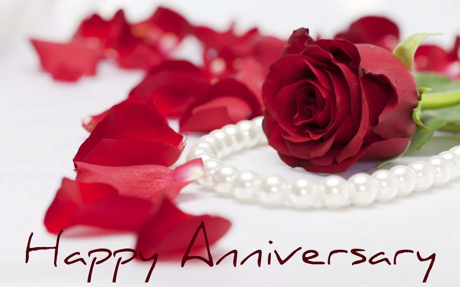 Caption: Elegant Pearl Necklace Adorning A Red Rose On A Romantic Anniversary Background
