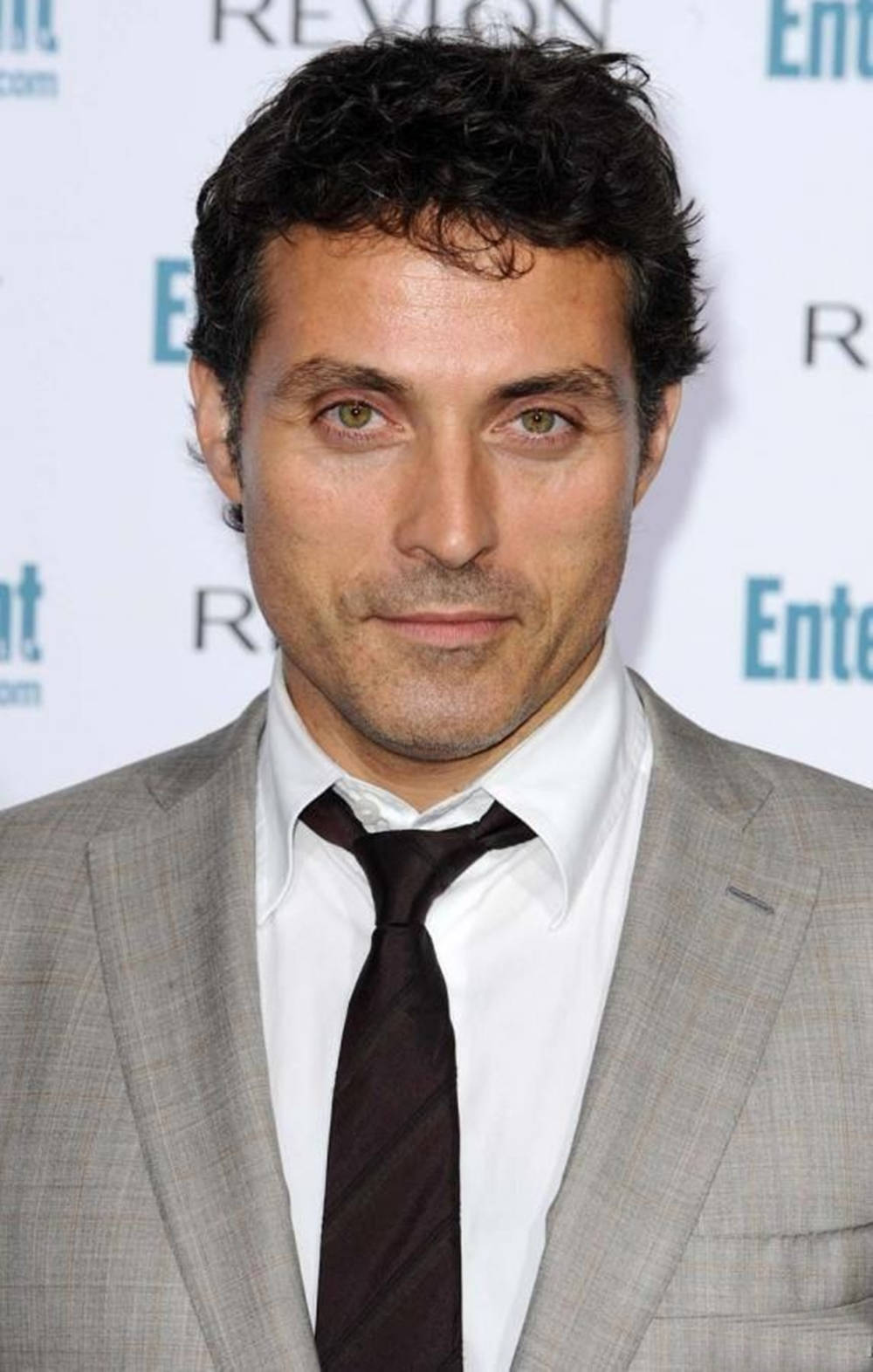 Caption: Elegant Rufus Sewell In A Gray Suit And Black Tie. Background