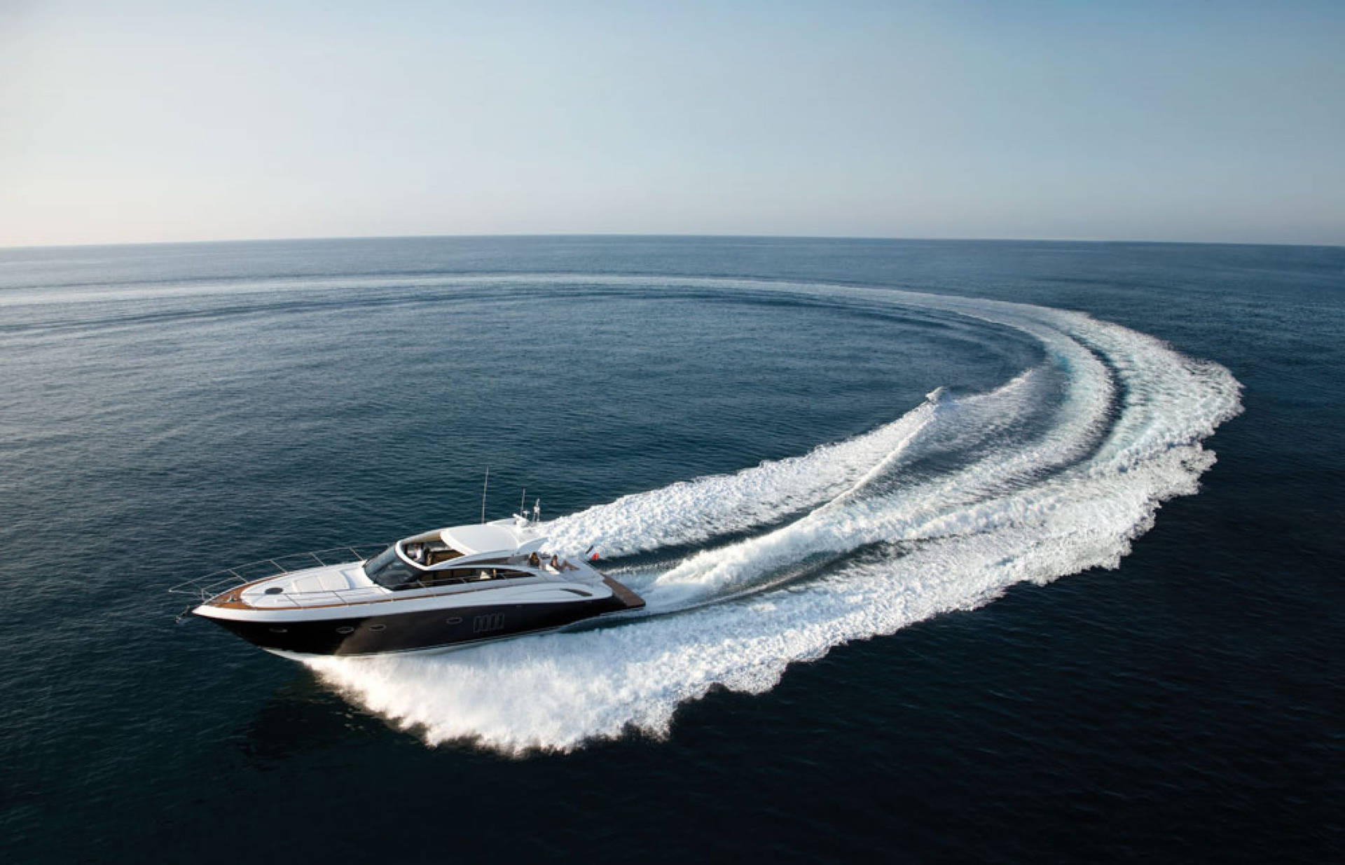 Caption: Elegant Yacht Cutting Through Ocean Waves Background