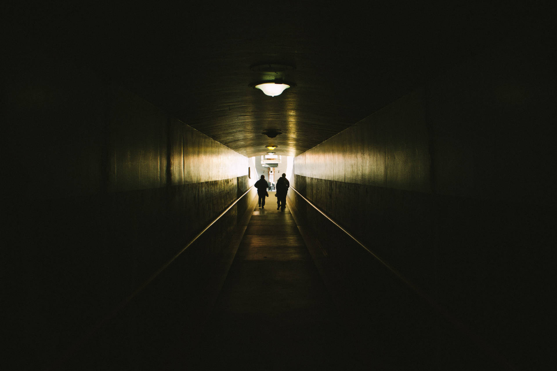 Caption: Embodying Pessimism Through A Dark Corridor Background