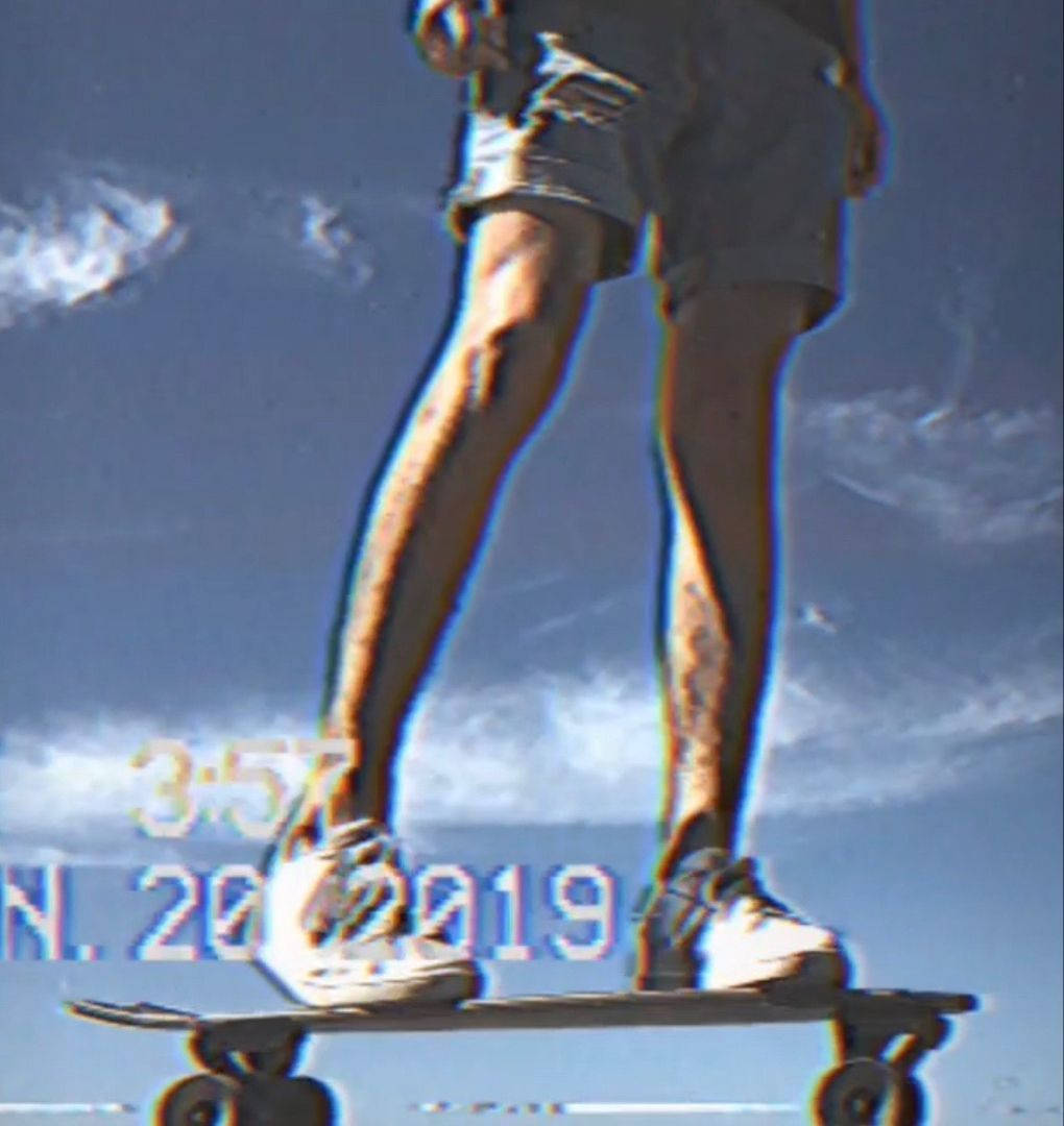 Caption: Embracing Freedom: Vintage Skater Against Blue Sky Background