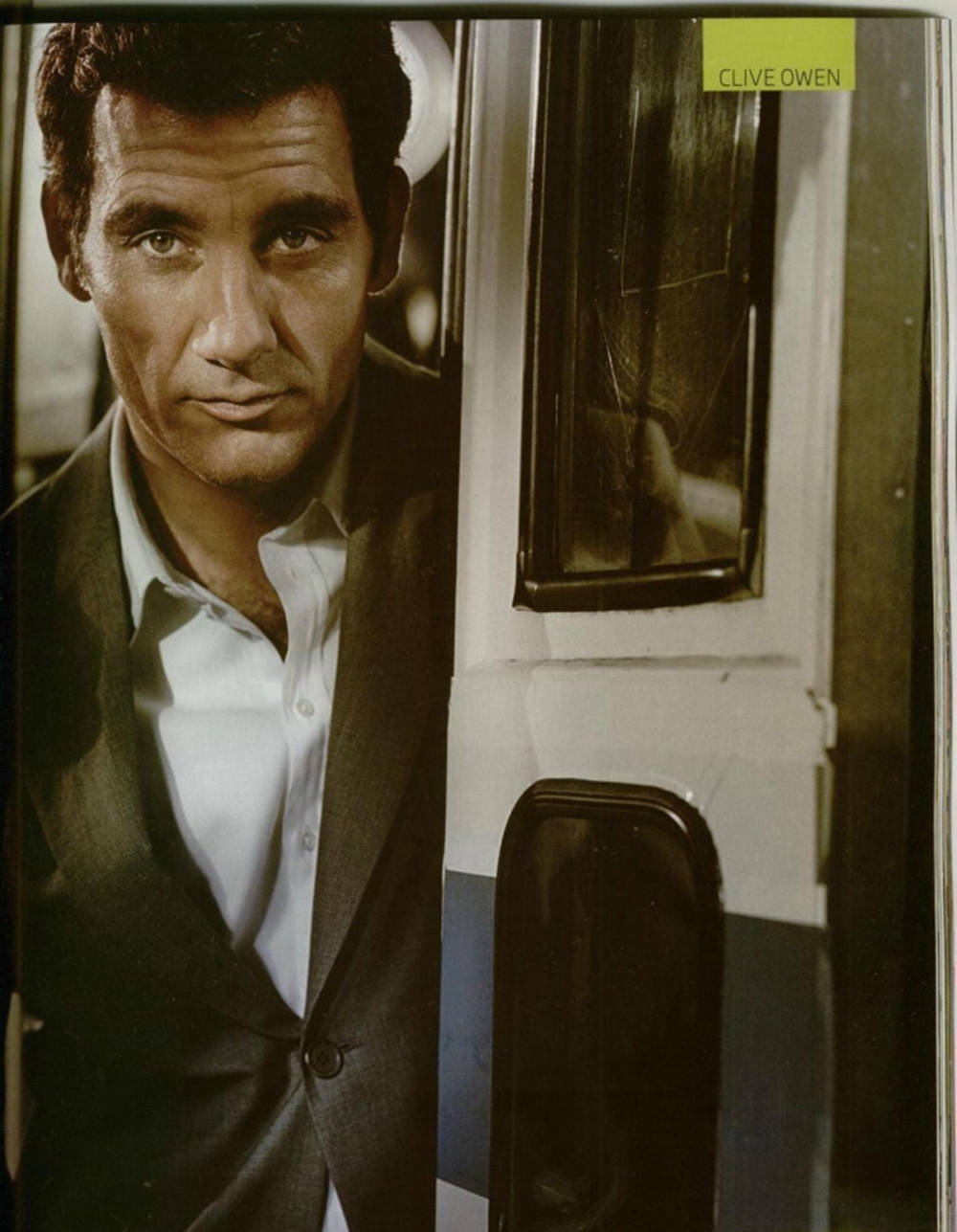 Caption: English Actor Clive Owen Posing By The Door Background