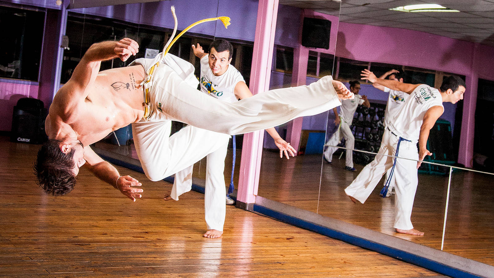 Caption: Enthralling Capoeira Practice In A Dance Studio Background