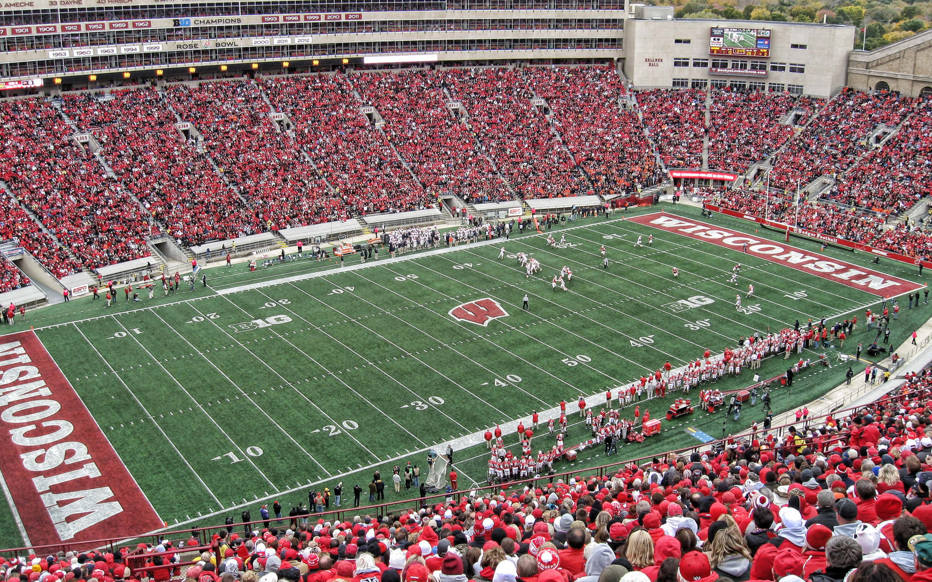 Caption: Enthusiastic Wisconsin Badgers Fans In The Stadium Background