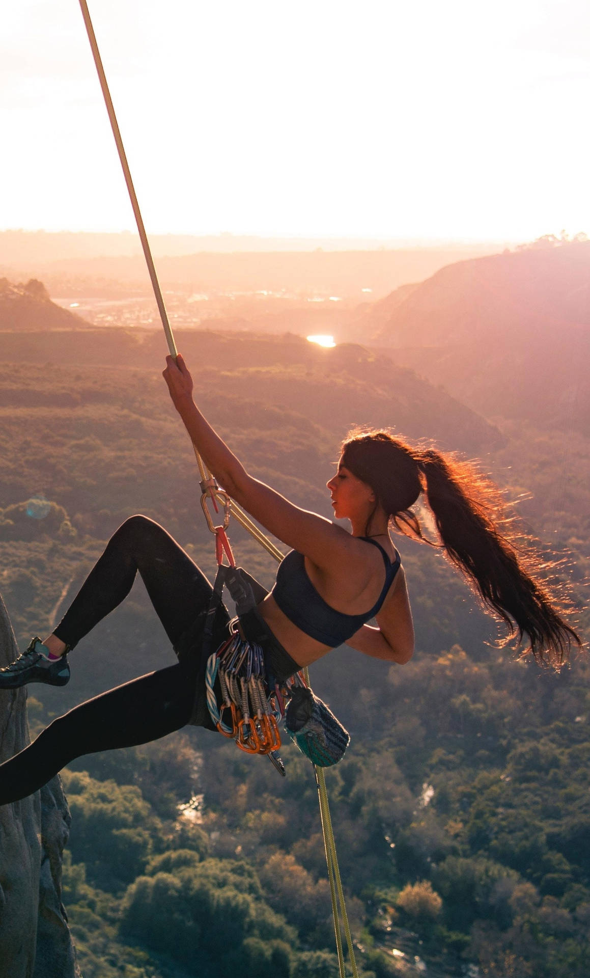 Caption: Fearless Female Rock Climber Ascending A Cliff