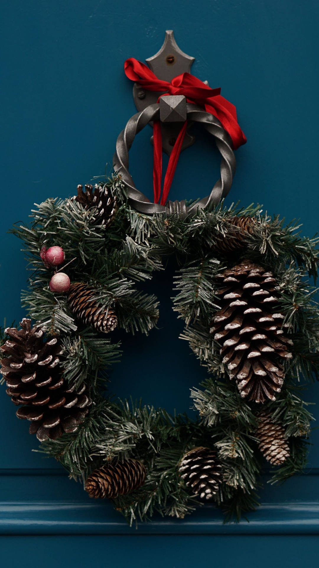 Caption: Festive Christmas Wreath Embellished With Pinecones Background