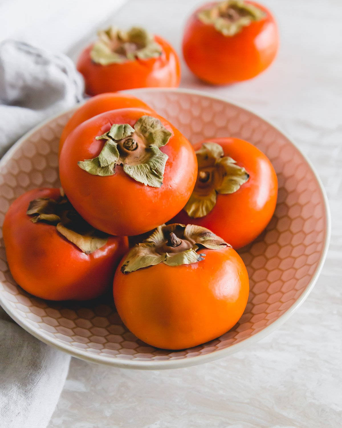 Caption: Fresh Persimmons In A Porcelain Bowl On Rustic Table Background