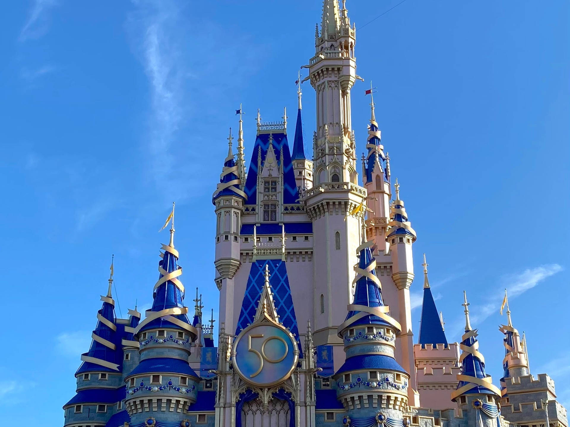 Caption: Glistening Disney Castle Under A Bright, Sunny Sky. Background