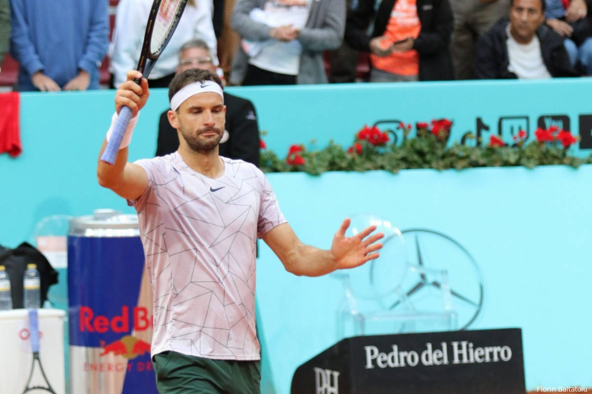 Caption: Grigor Dimitrov In Action - Triumphantly Holds Up Tennis Racket Background