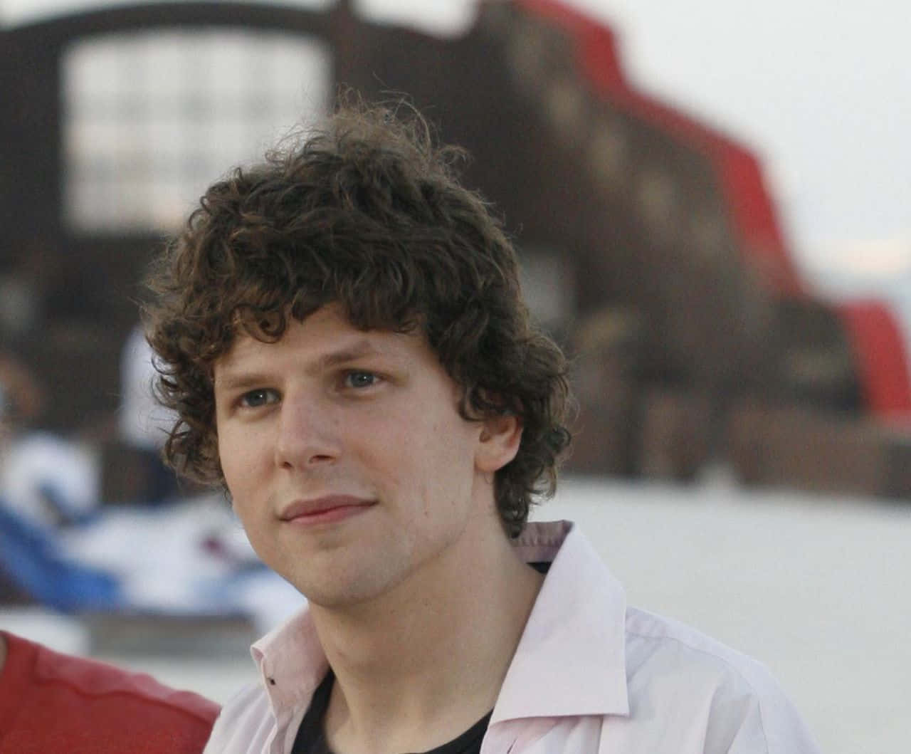 Caption: Hollywood Actor Jesse Eisenberg Gazing Into The Distance Background