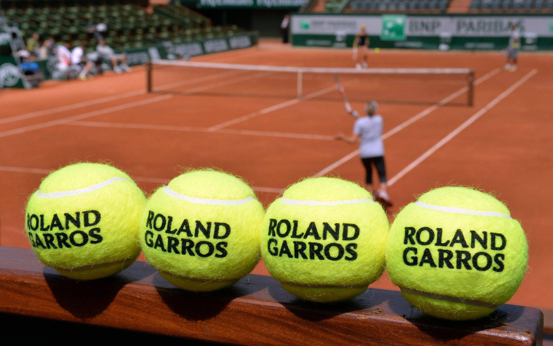 Caption: Iconic Clay Courts - A Close-up View Of Tennis Balls At The French Open Background