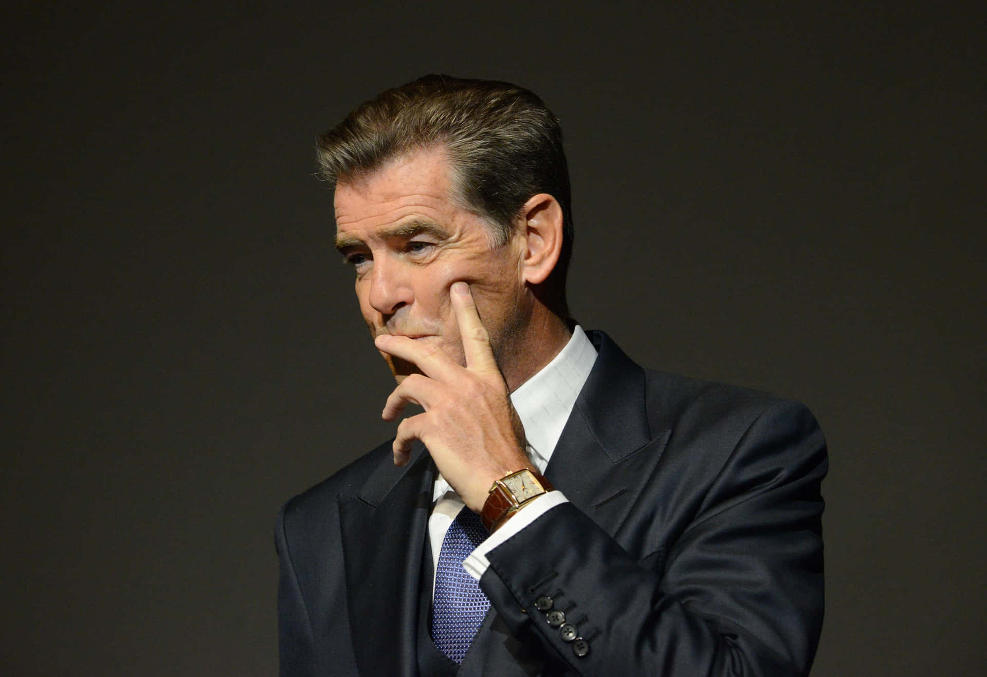 Caption: Iconic Pierce Brosnan In A Thoughtful Pose Background