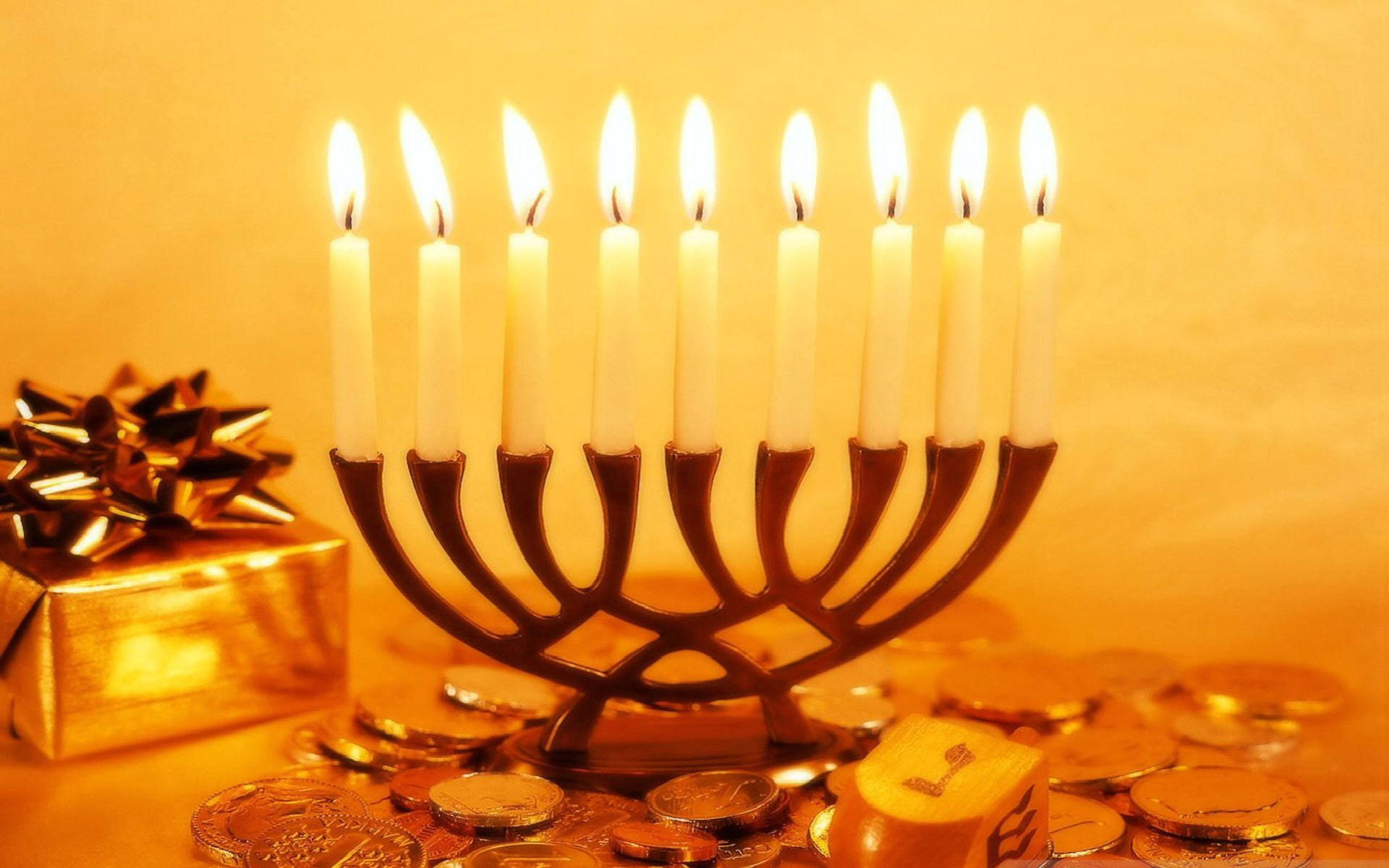 Caption: Illuminating Hanukkah Celebration With Traditional Coins And Candles Background