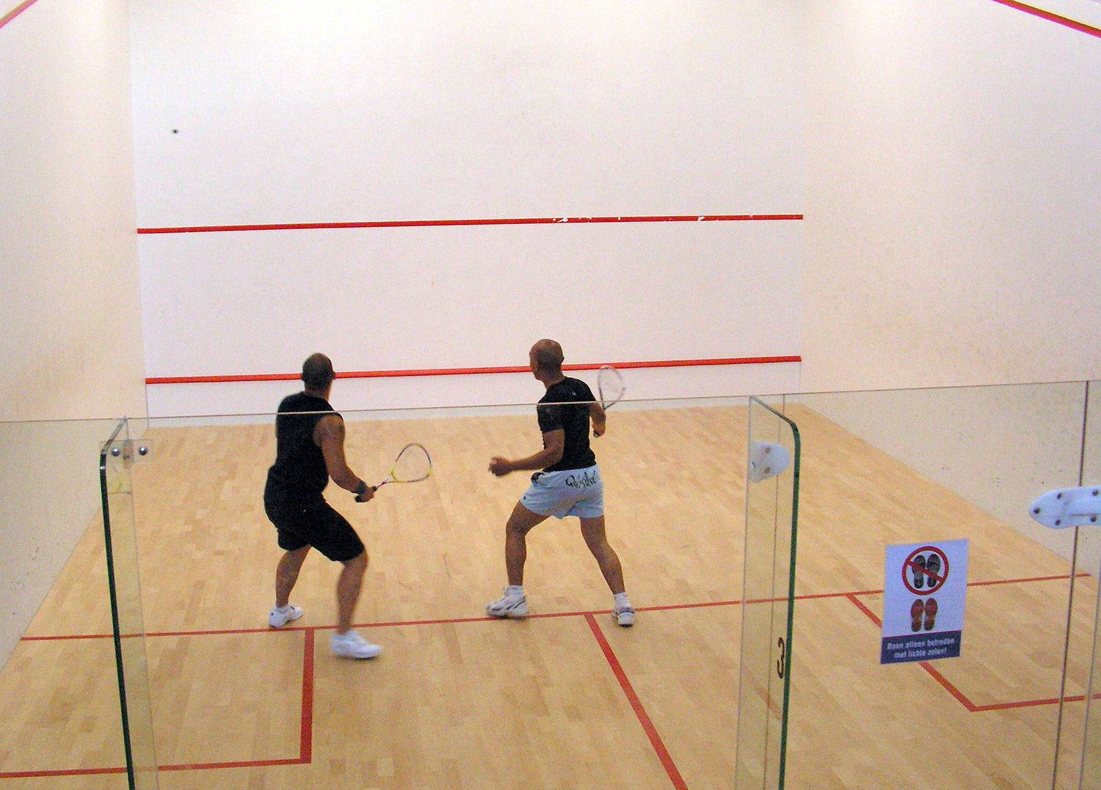 Caption: Intense Racquetball Match In Action Background