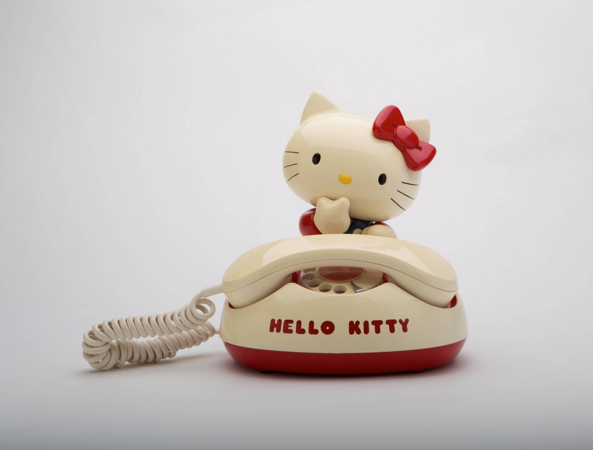 Caption: Interactive Hello Kitty At Desk With Telephone Wallpaper Background