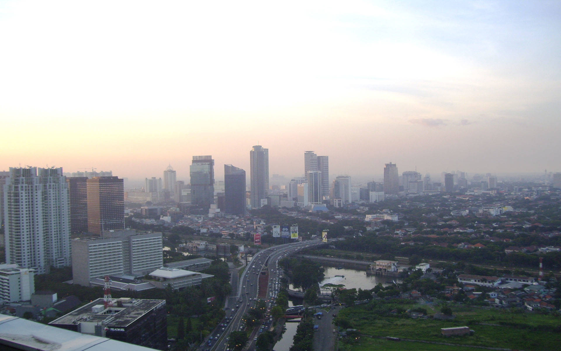 Caption: Jakarta's Majestic City Skyline At Dusk Background
