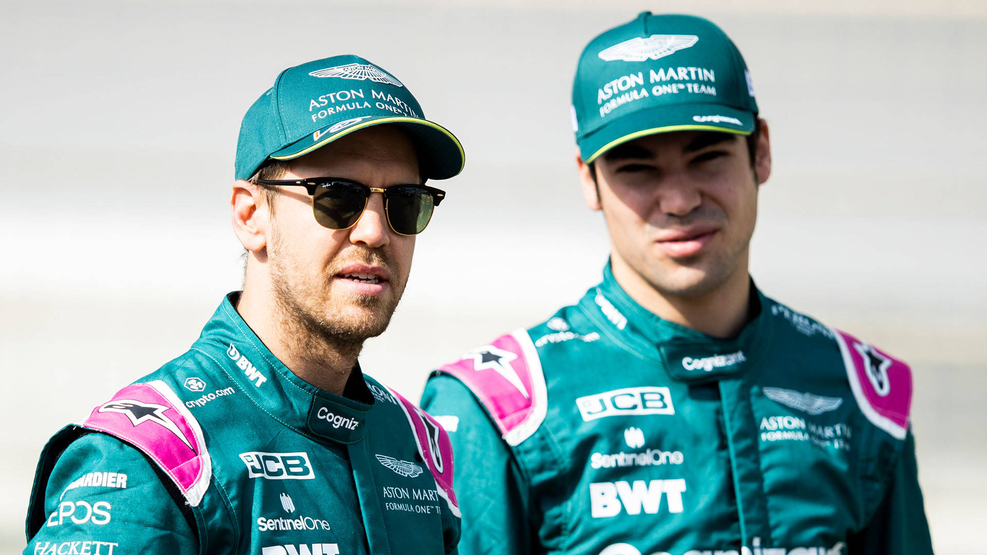 Caption: Lance Stroll And Sebastian Vettel In Intense Discussion During An F1 Event. Background