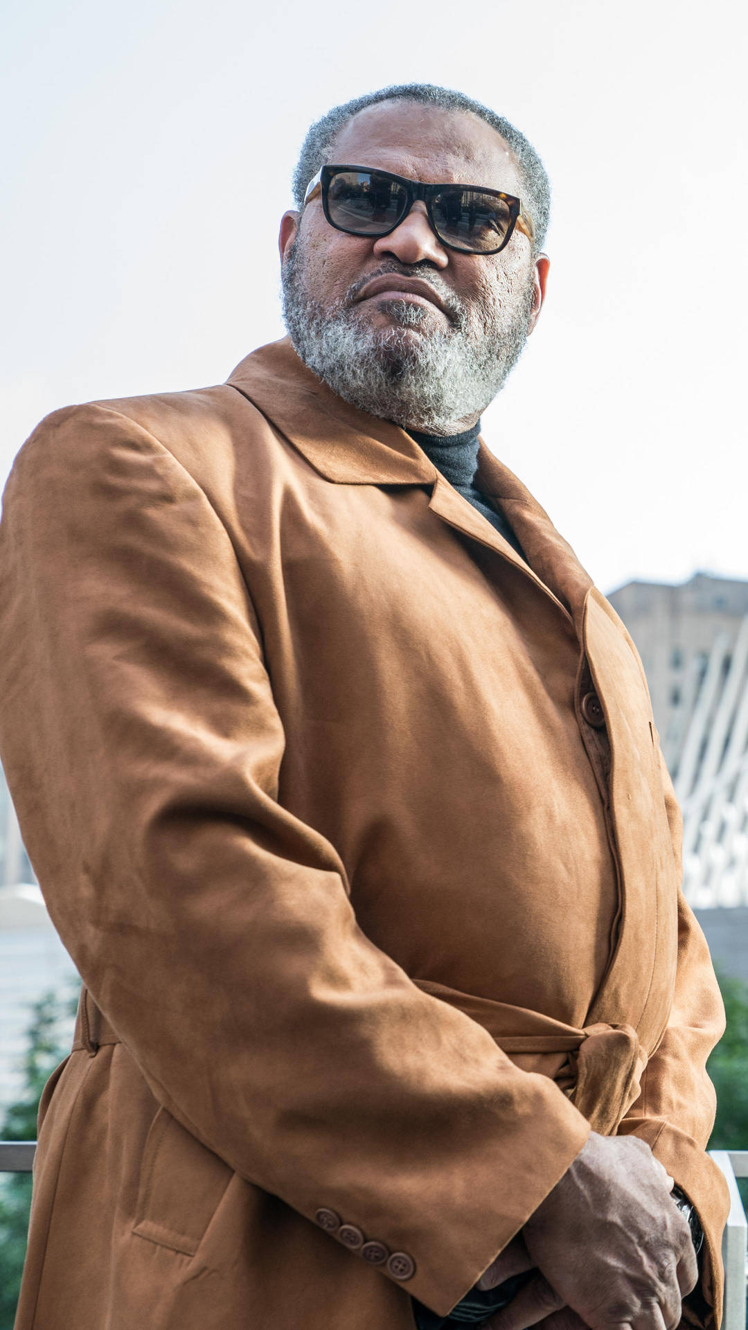 Caption: Laurence Fishburne In Distinctive Brown Coat Background