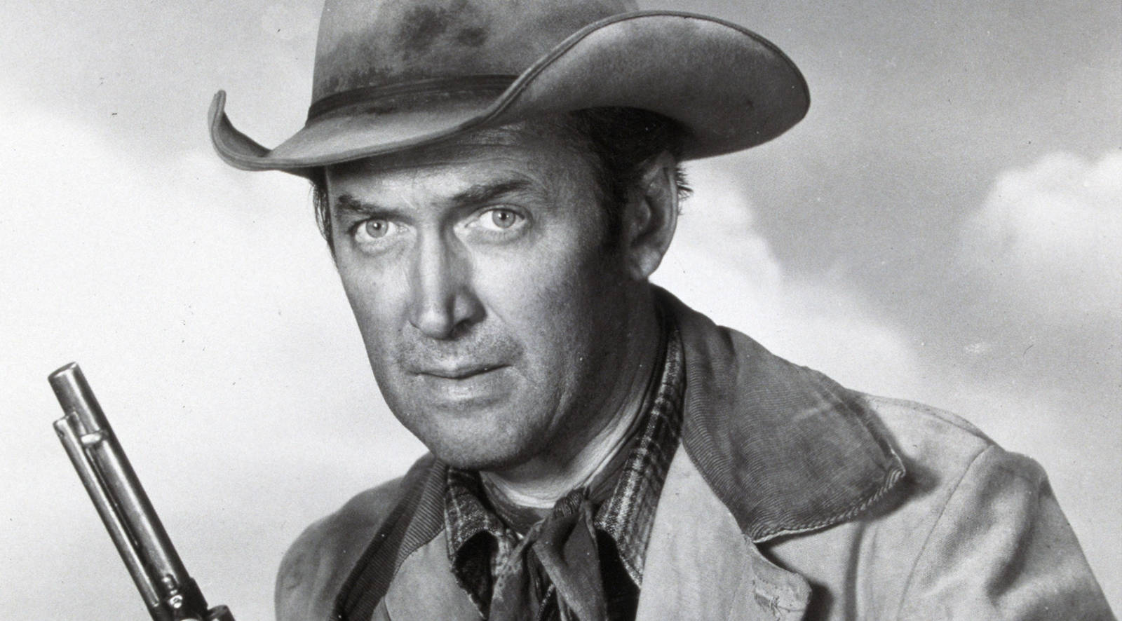 Caption: Legendary Actor James Stewart Exuding An Effortless Cowboy Style. Background