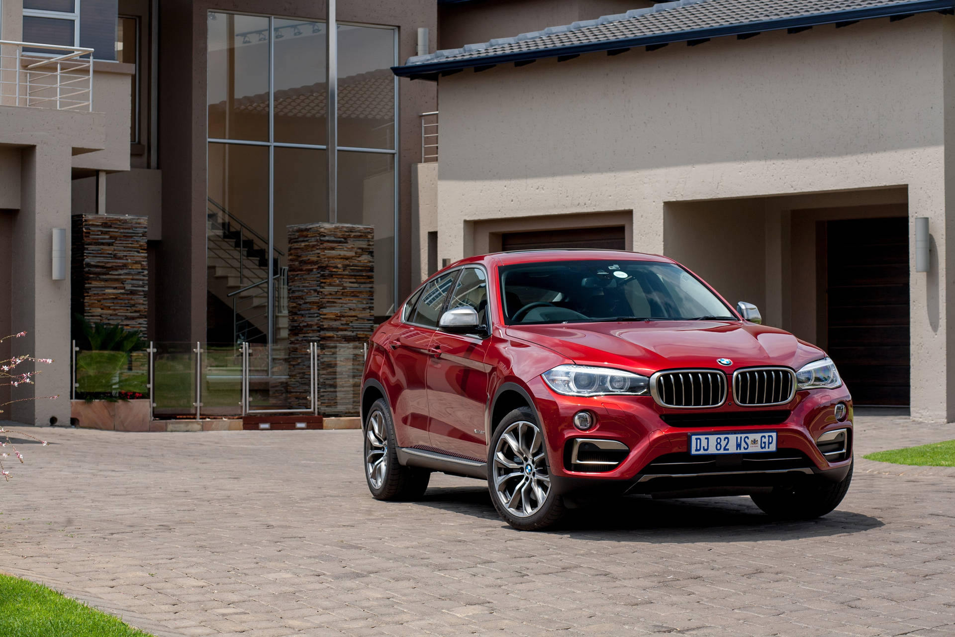 Caption: Luxurious Bmw X6 M Parked Outside A Modern House