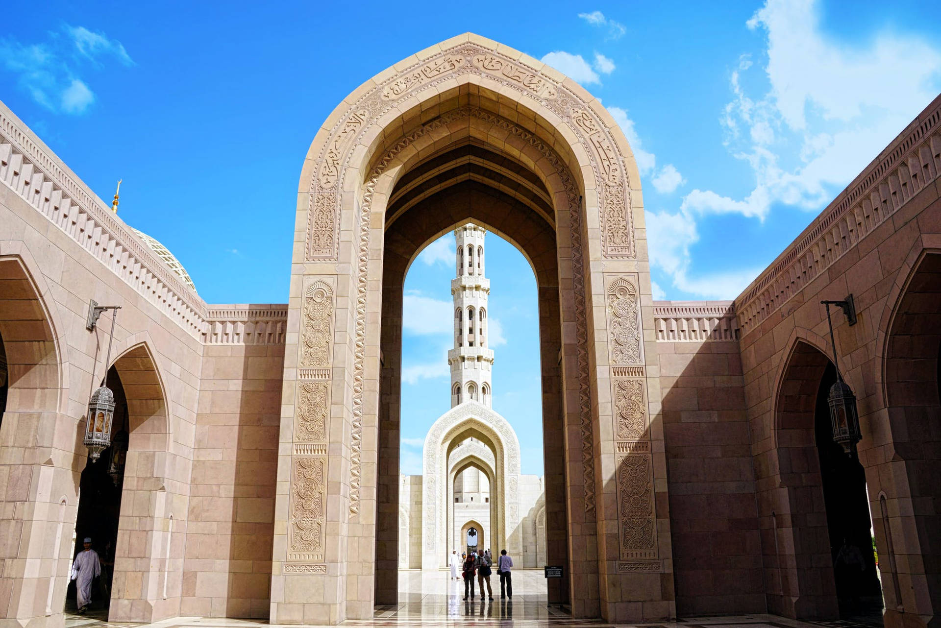 Caption: Magnificent Muscat Mosque Under A Blue Omani Sky Background