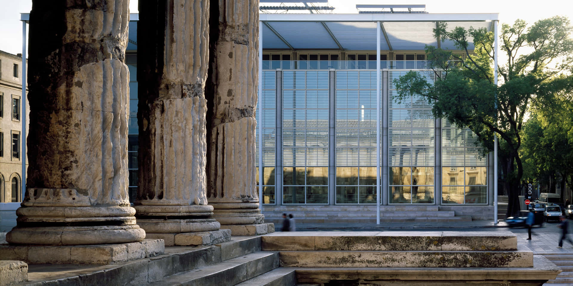Caption: Maison Carrée Juxtaposed With Modern Architecture Background