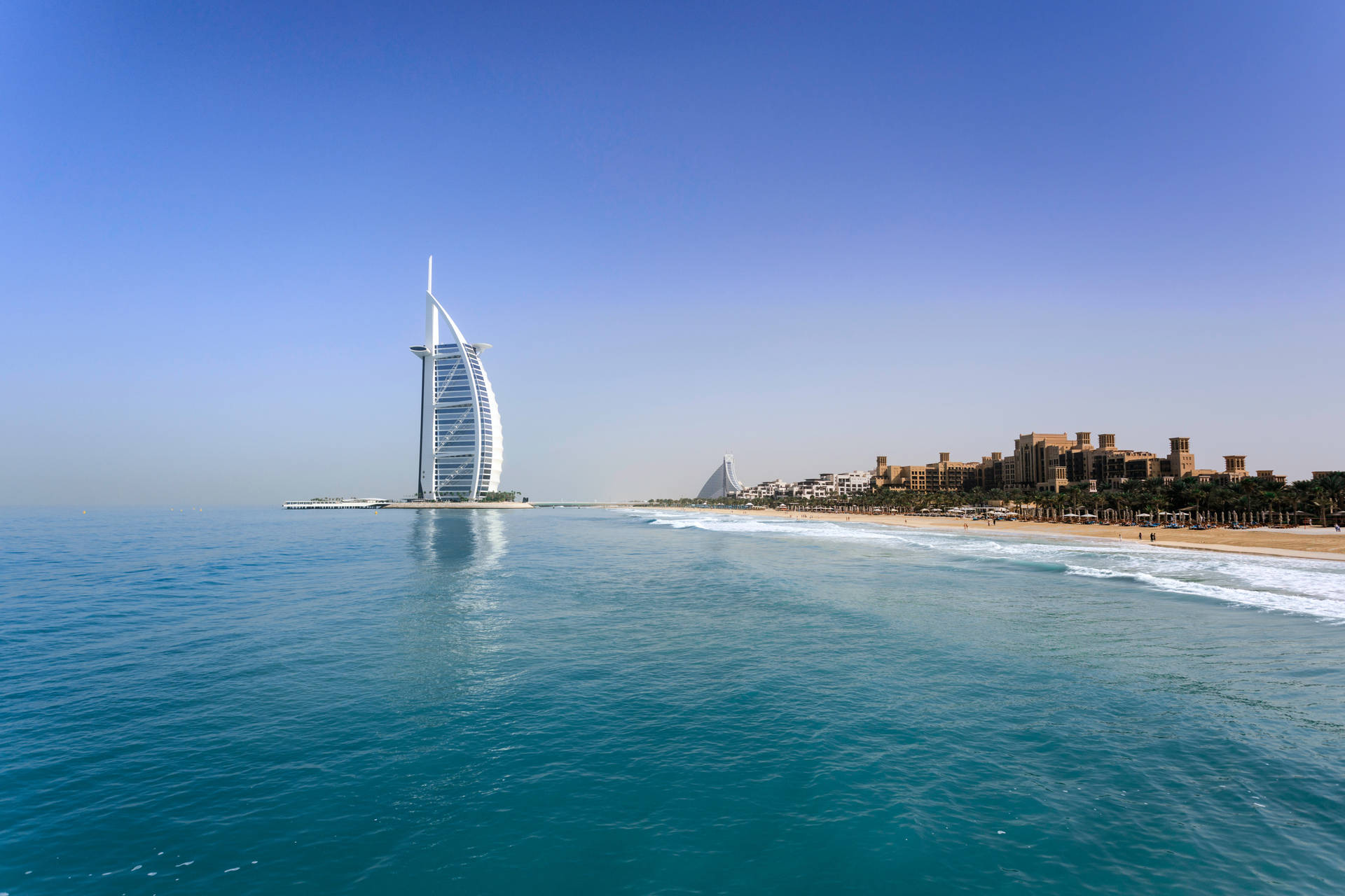 Caption: Majestic Burj Al Arab Under The Clear Sky Background