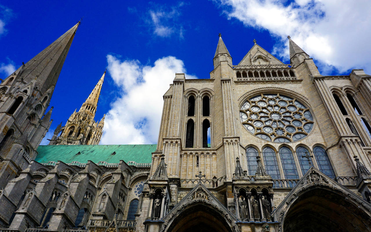 Caption: Majestic Chartres Cathedral Against A Blue Sky Background