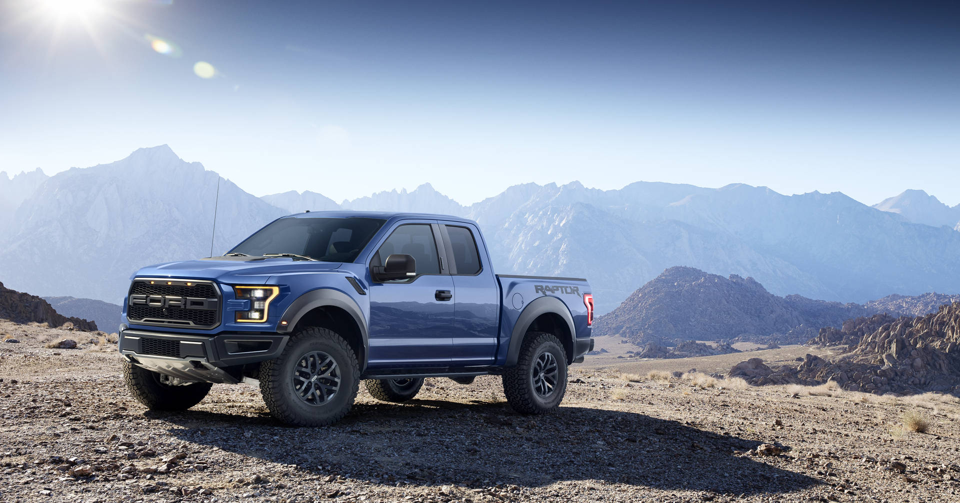 Caption: Majestic Ford Raptor Exploring Wild Mountain Terrains Background