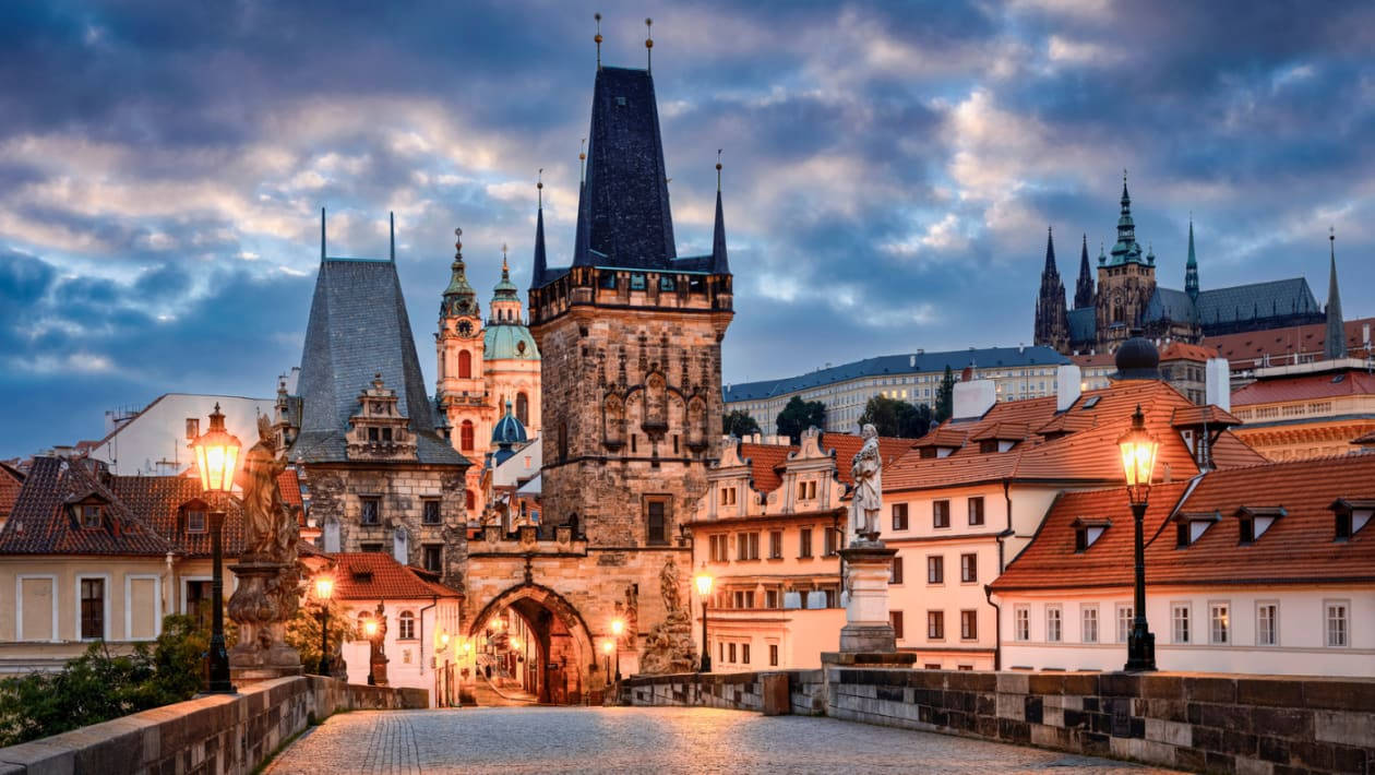 Caption: Majestic Gates Of Prague Castle At Dusk Background