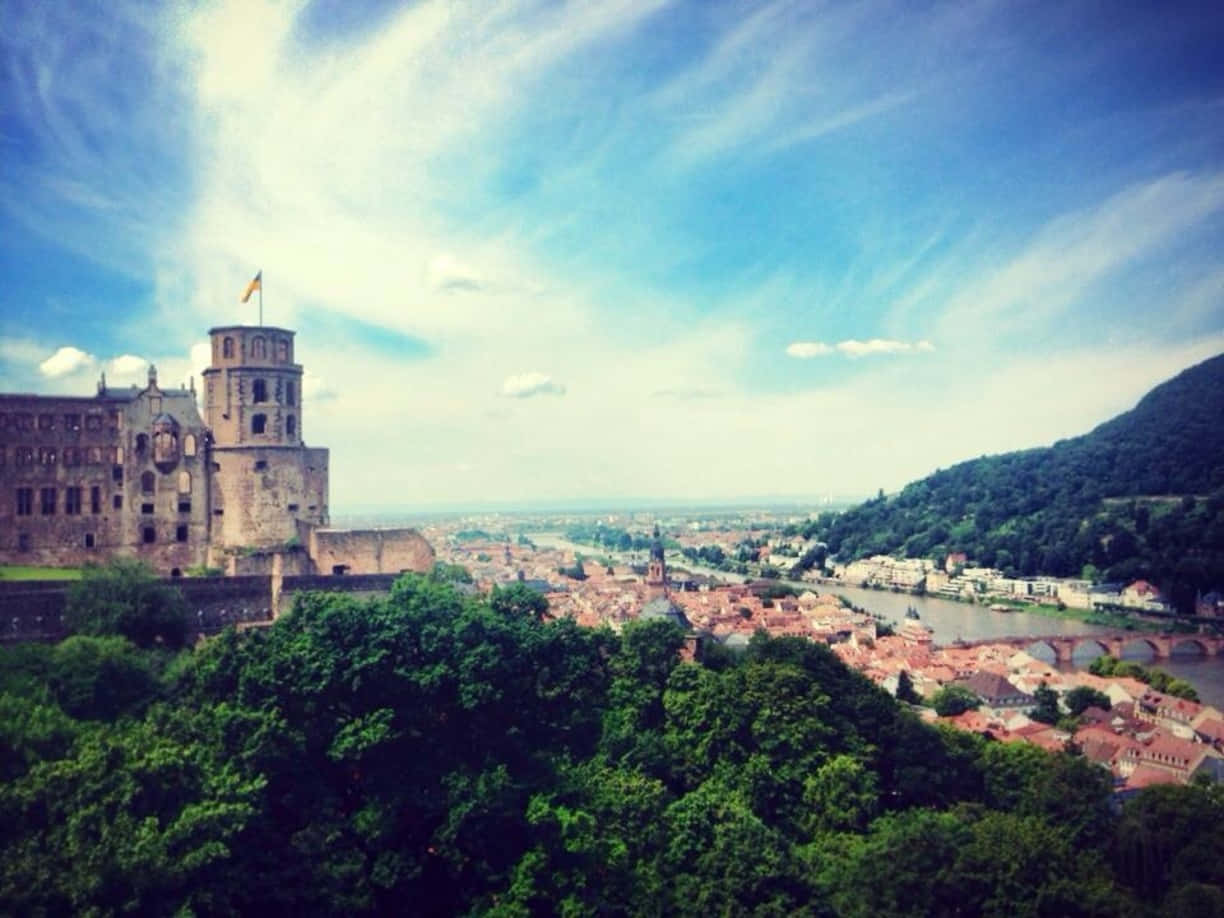 Caption: Majestic Heidelberg Castle Under Thin Clouds Background