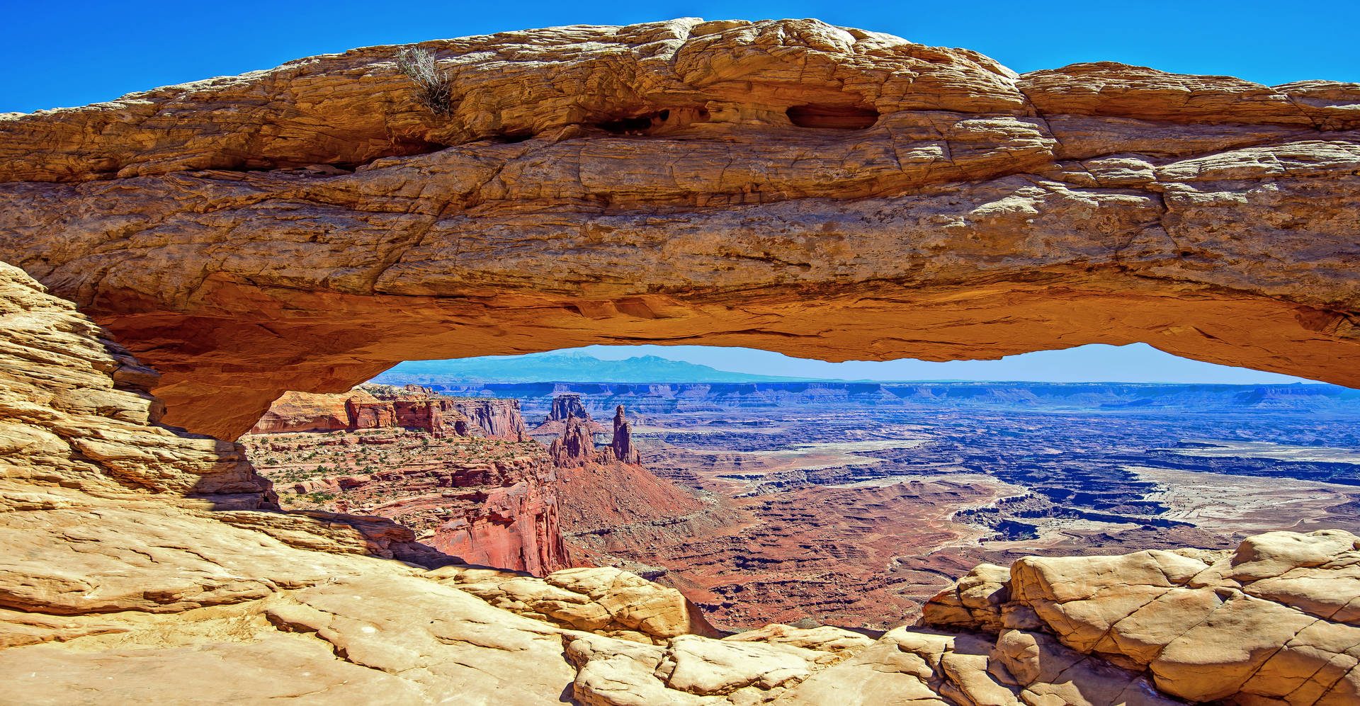 Caption: Majestic Long Rock Formation In Canyonlands National Park Background