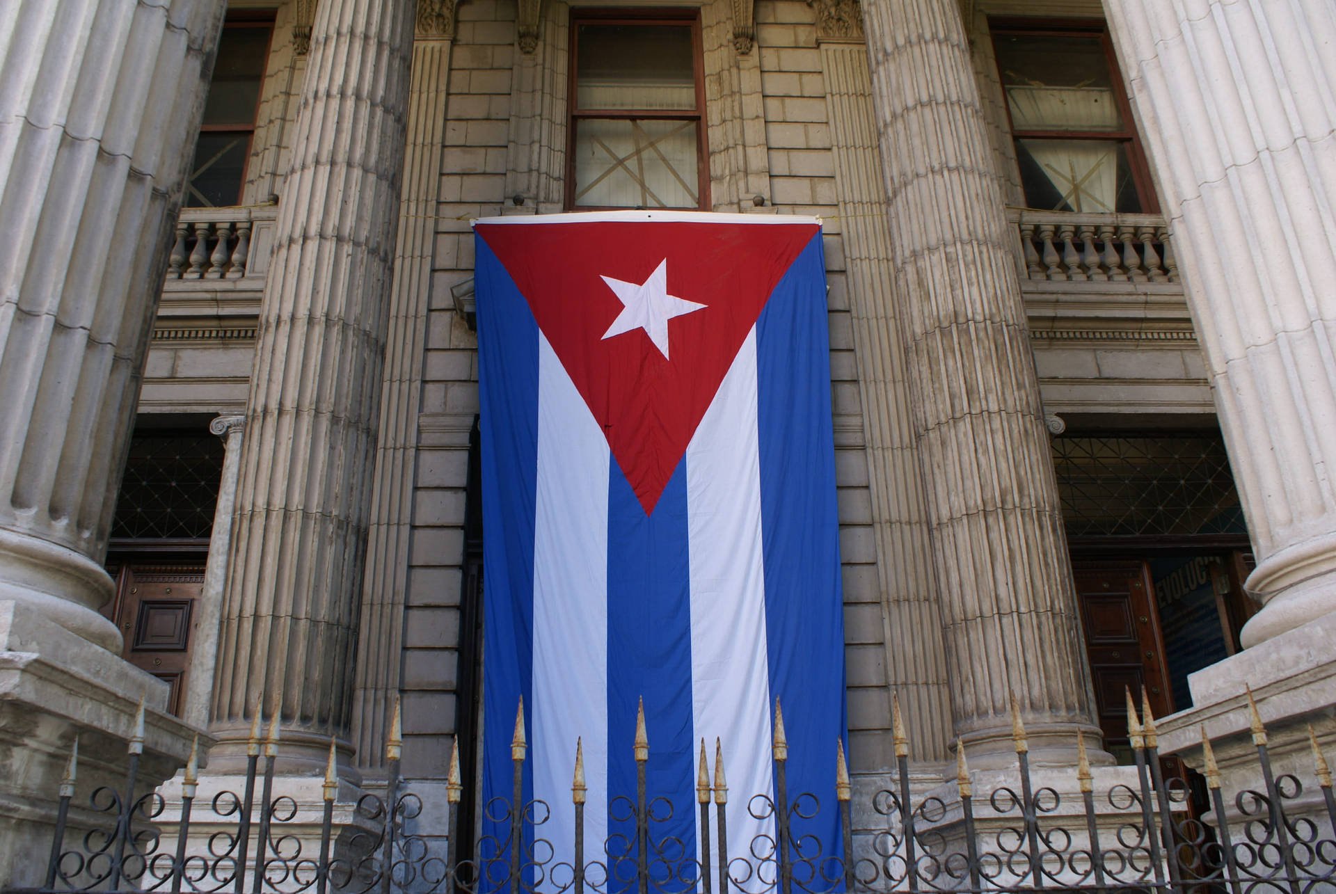Caption: Majestic Mansion Under The Emblematic Cuban Flag Background
