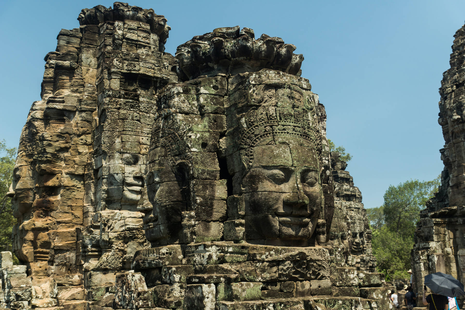 Caption: Majestic Stone Faces In Angkor Wat, Cambodia Background