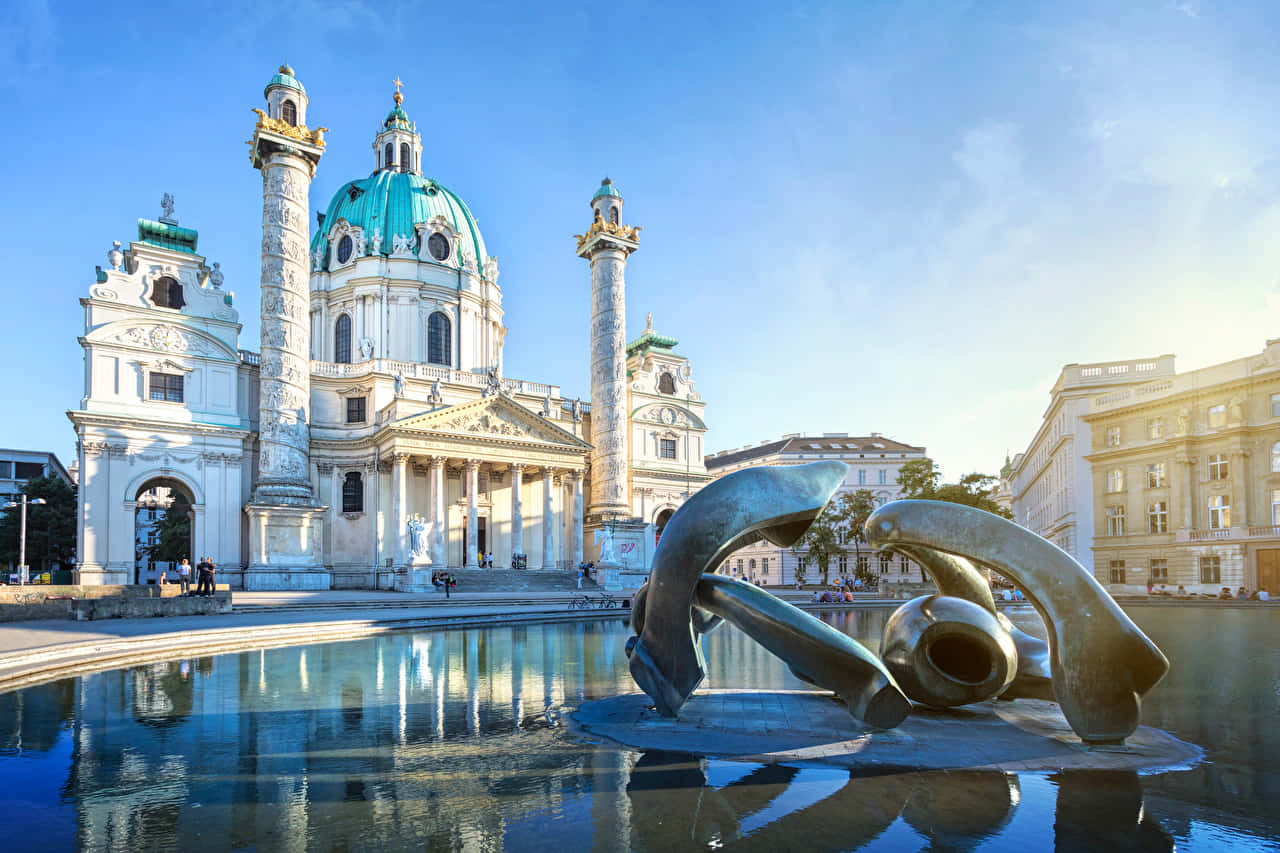 Caption: Majestic Vienna Cathedral Under The Clear Blue Sky Background