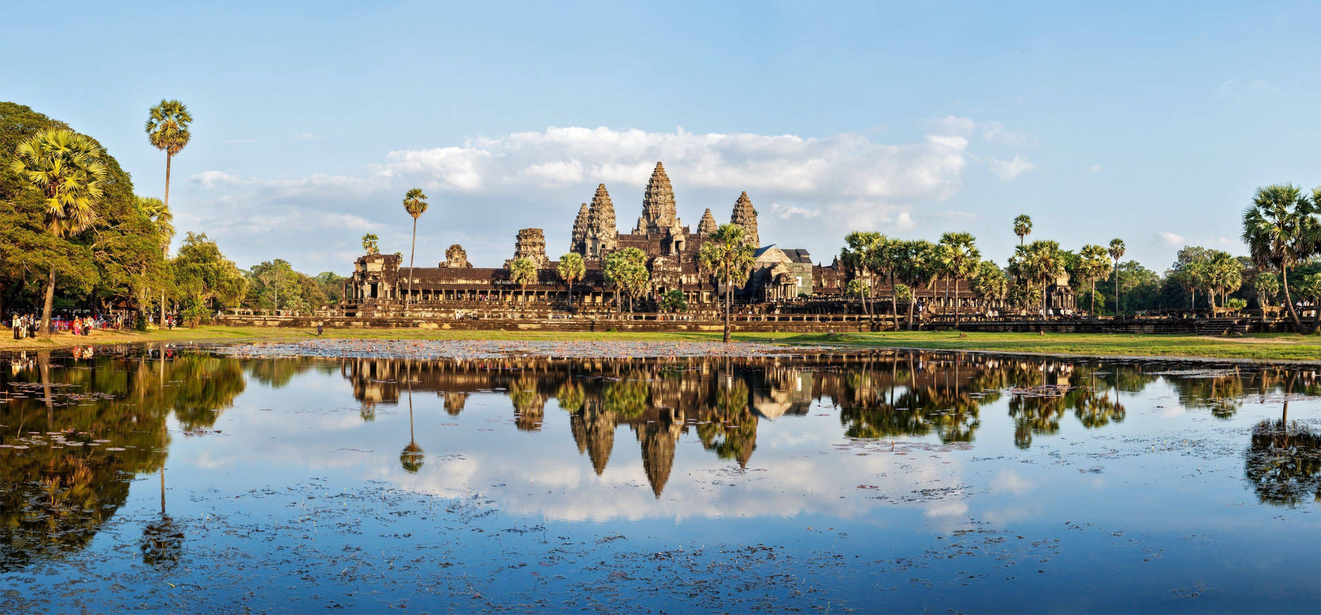 Caption: Majestic View Of Angkor Wat Reflecting Under The Azure Sky Background