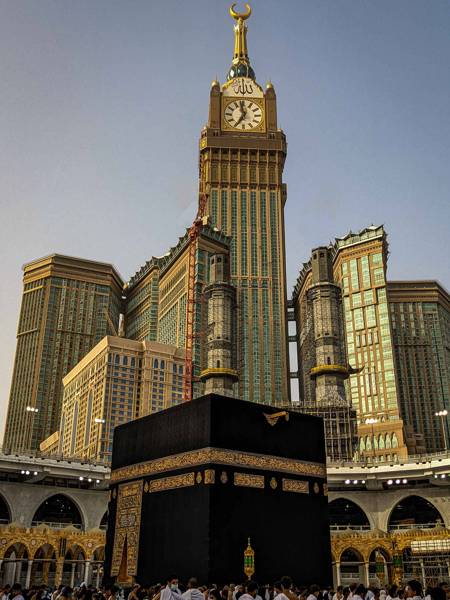 Caption: Majestic View Of The Clock Tower And Kaabah In Makkah Madina Background