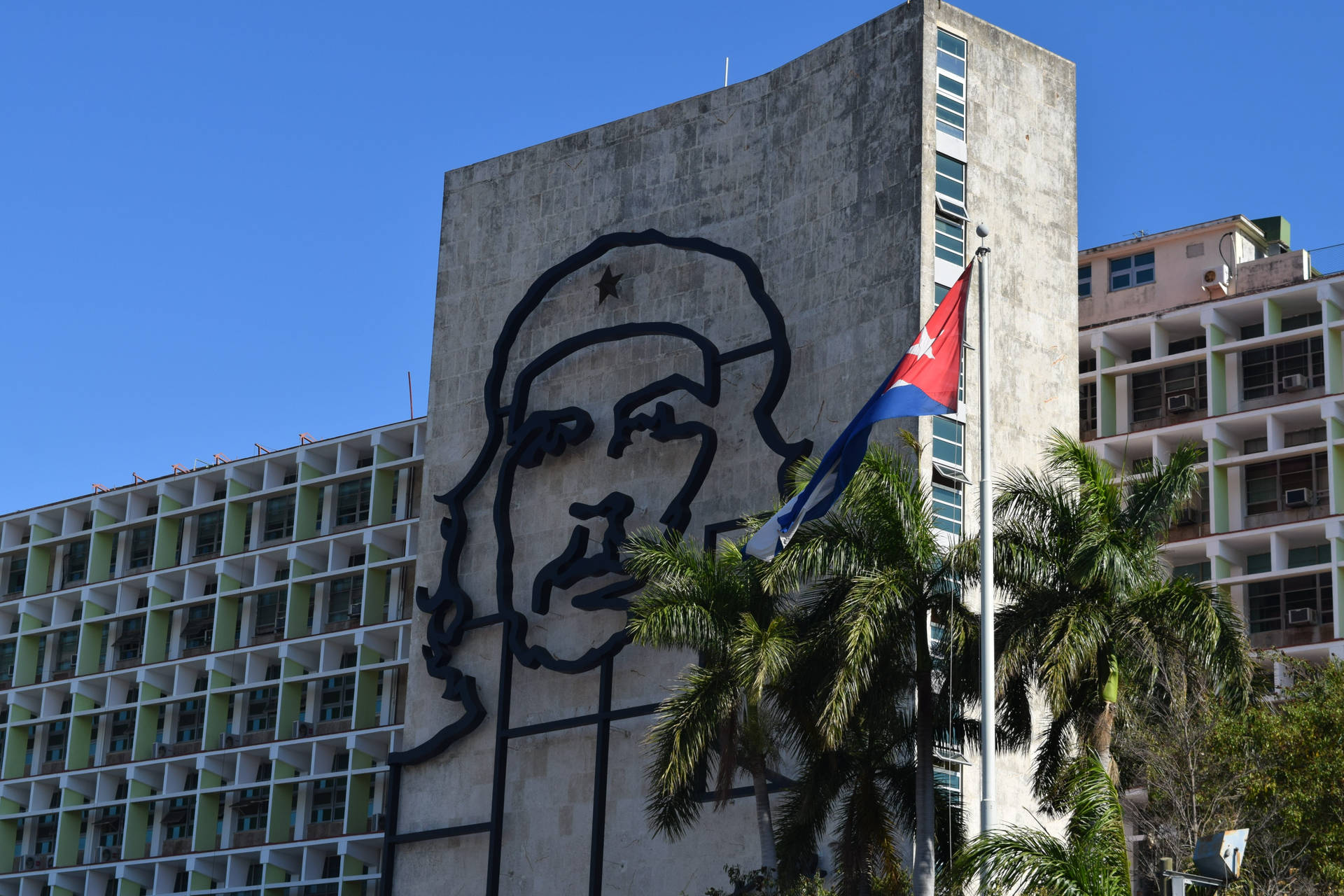 Caption: Majestic View Of The Cuban Flag Flying High At The Havana Steel Memorial. Background