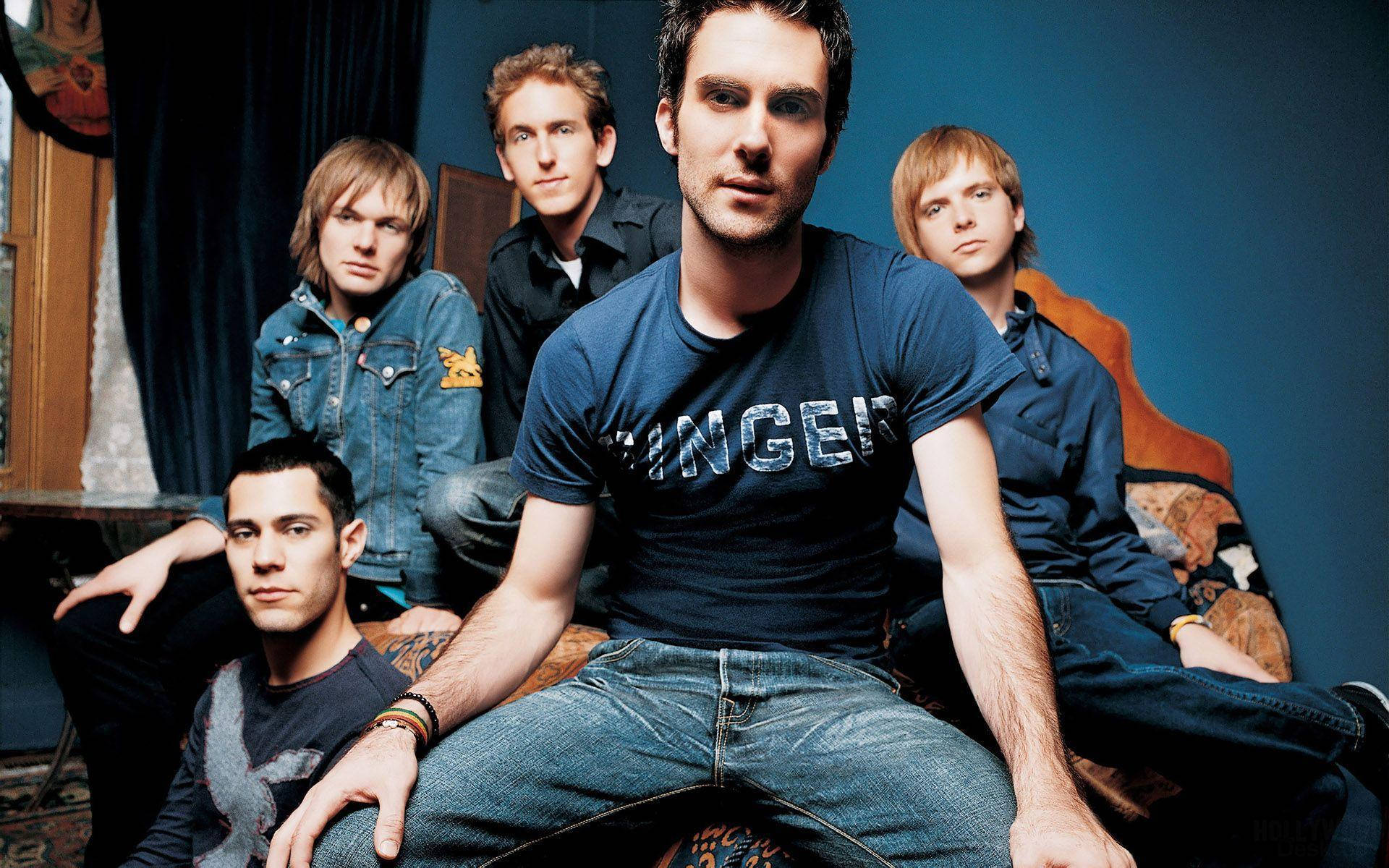 Caption: Maroon 5 Band Members In Blue Ensemble In A Blue Room Background