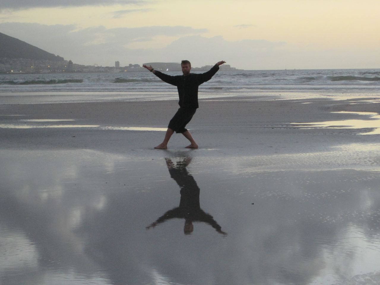 Caption: Martial Artist Practicing Bagua By The Sea Background