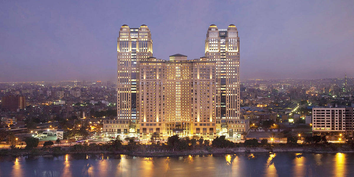 Caption: Mesmerizing View Of The Fairmont Nile City Cairo Hotel At Sunset Background