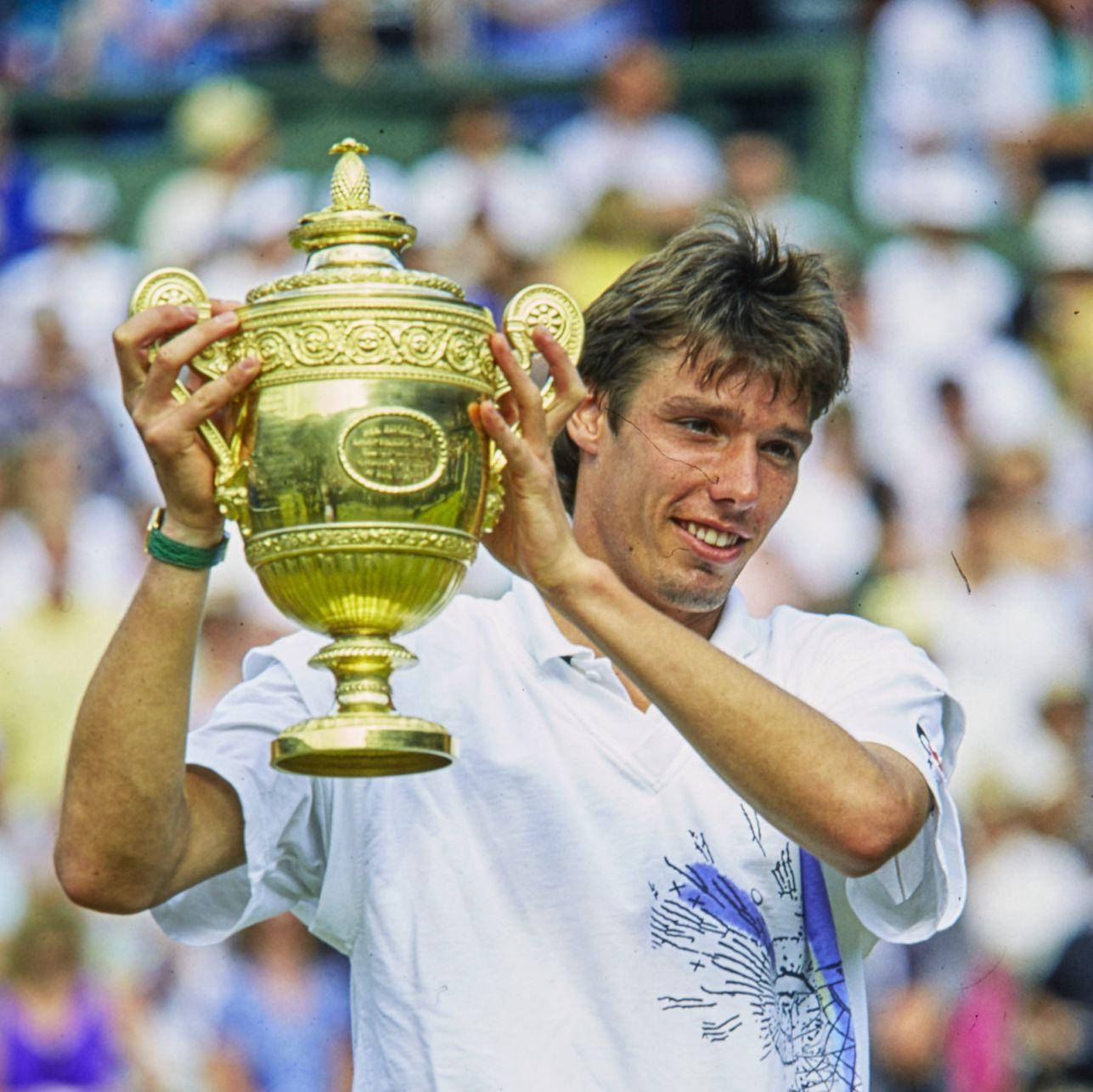 Caption: Michael Stich Triumphantly Holding A Tennis Trophy Background