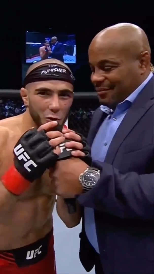 Caption: Muhammad Mokaev Engaged In A Thought-provoking Conversation Background