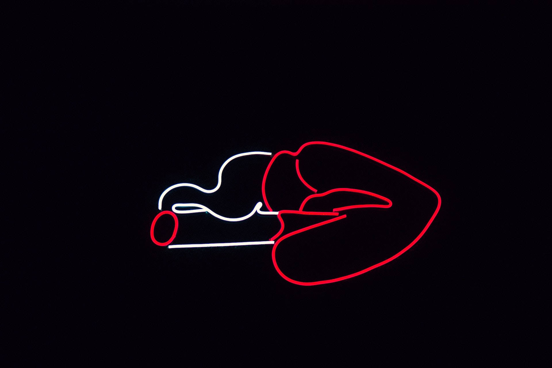 Caption: Neon Lips Sign Against A Dark Background Background