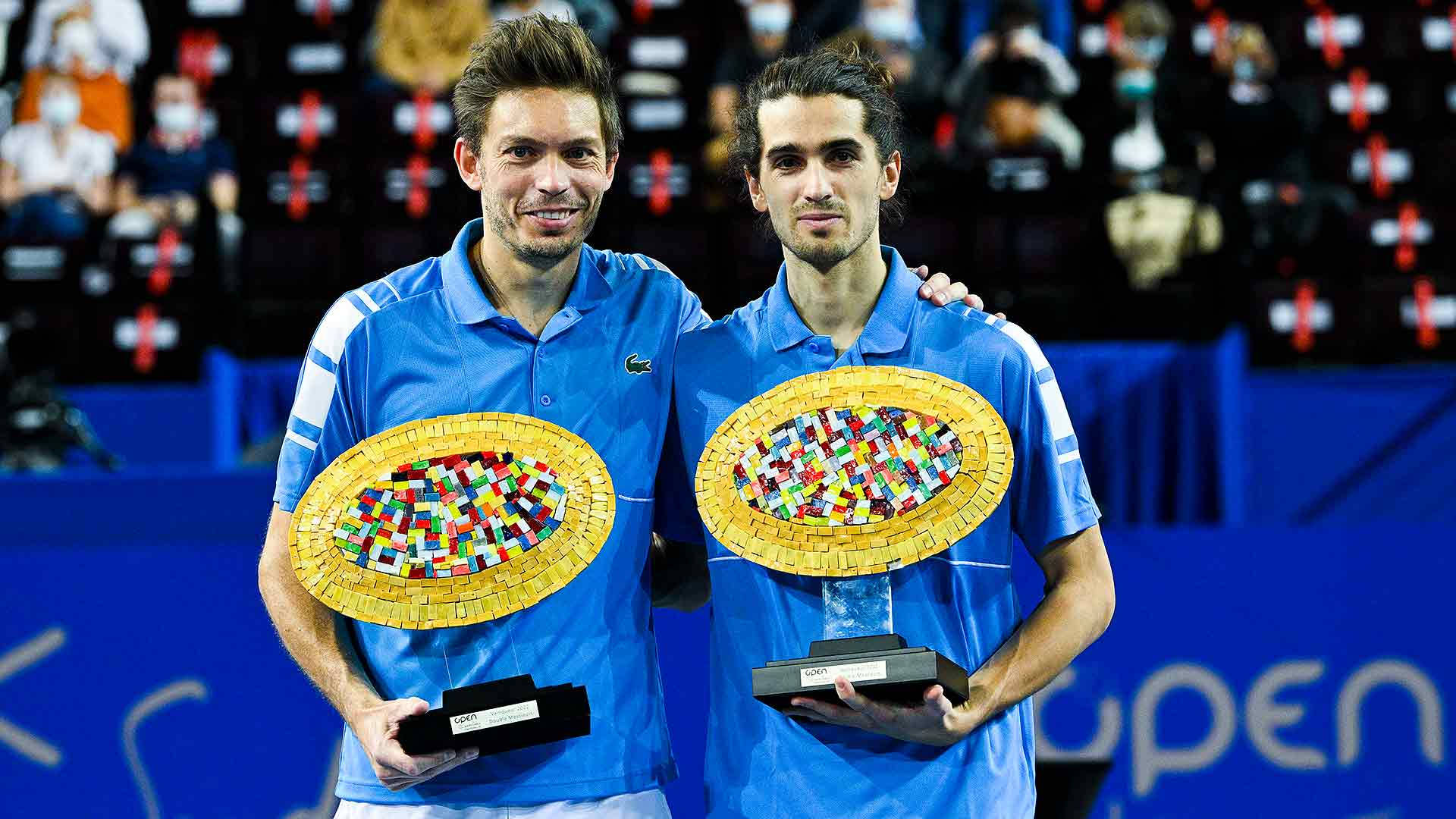 Caption: Nicolas Mahut Triumphantly Holding Montpellier Trophy Background