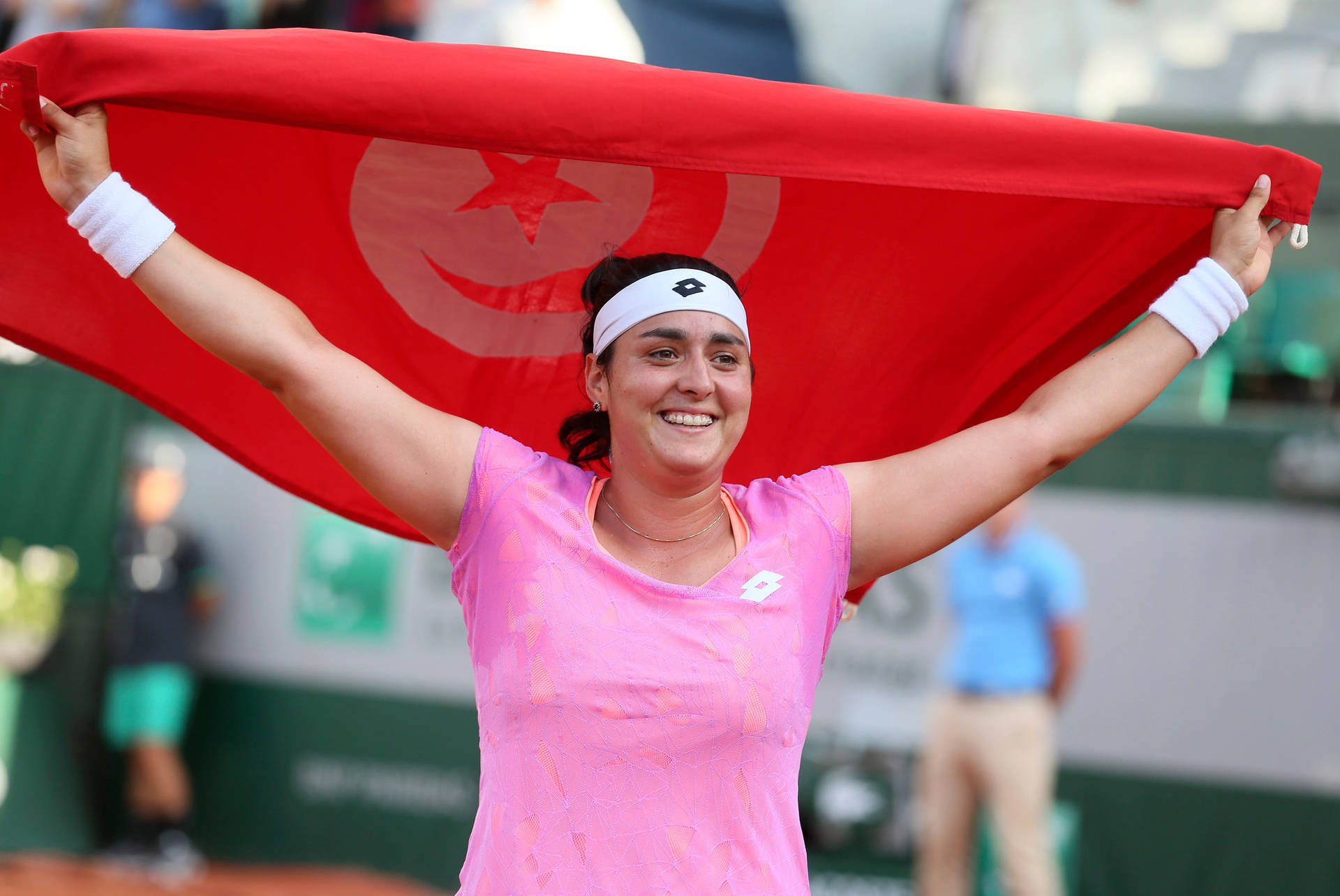 Caption: Ons Jabeur Holds High The Tunisian Flag In Celebration Background